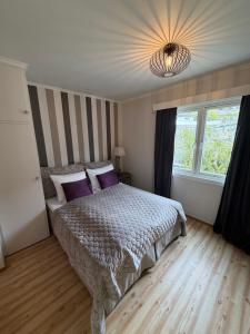 a bedroom with a large bed with purple pillows at Hofslund Apartments in Sogndal