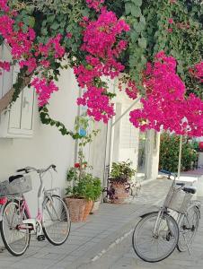 two bikes parked in front of a building with pink flowers at Thalassa Kai almira studios in Sarti