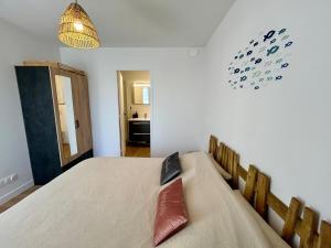 a bedroom with a bed and a clock on the wall at Le 200 de la cale in Fouesnant