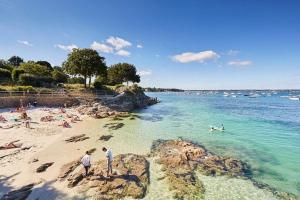 a group of people on a beach near the water at Le 200 de la cale in Fouesnant