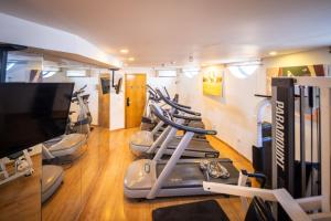 a gym with a row of exercise bikes and a flat screen tv at Superb Beachfront Apartments with Shelter by Sea N' Rent in Tel Aviv