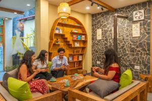 a group of people sitting around a table in a restaurant at The Social Stays Kasol in Kasol