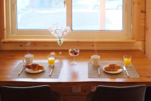 a table with two plates of food and glasses of orange juice at Banksia Seaside Cottage in Ōami