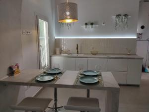 a kitchen with a table with plates and wine glasses at La corrala de la calle Sol in Jerez de la Frontera