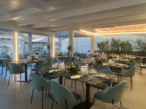 a dining room with tables and chairs and windows at Hotel Sant'Antonio in Torraca