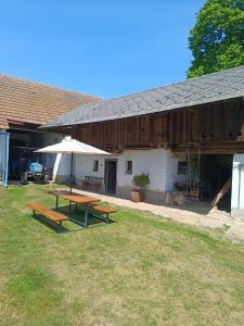 a picnic table and an umbrella next to a barn at Chalupa u dědy in Kozlov