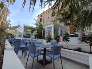 a restaurant with blue tables and chairs and palm trees at Hotel Sant'Antonio in Torraca