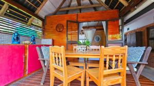 a dining room with a wooden table and chairs at Crabb Cottage and escape in St Lucia