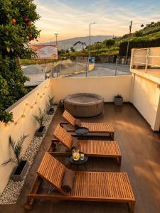 a rooftop patio with benches and a fire pit at Casa Carvalho in Peso da Régua