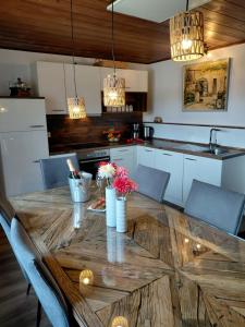 a kitchen with a wooden table with flowers on it at s' Kännele Ferienwohnungen in Mudau