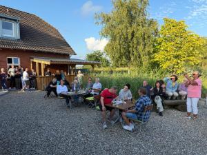 a group of people sitting at tables in a yard at Gaststätte Bongsiel 'Dat Swarte Peerd' in Ockholm