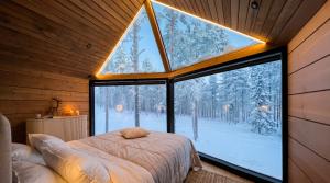 a bedroom with a bed and a large window at Levi Nordic Star Igloos in Levi