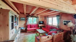 a living room with red couches in a log cabin at Magnifique chalet , 10 personnes, vue panoramique, bain nordique in Passy