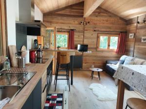a kitchen and living room of a log cabin at Magnifique chalet , 10 personnes, vue panoramique, bain nordique in Passy