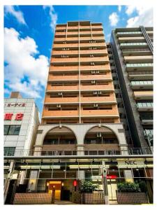 a tall apartment building with a large building at Hotel Arashi Nippombashi 2 No008 in Osaka