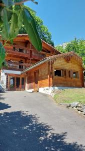 a large wooden building with a road in front of it at Magnifique chalet , 10 personnes, vue panoramique, bain nordique in Passy