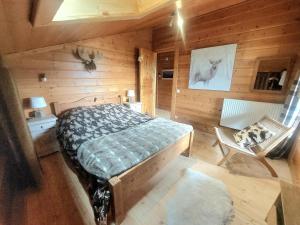 a bedroom with a bed in a wooden cabin at Magnifique chalet , 10 personnes, vue panoramique, bain nordique in Passy