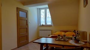 a room with a table and a bed and a window at Dworek Myśliwski in Łaziska