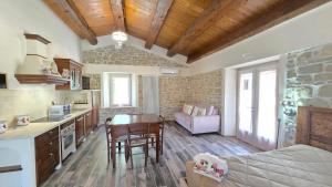 a kitchen and living room with a table and a couch at La Casetta Agriturismo in Santa Sofia