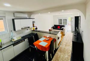 a kitchen and living room with a table in it at The Olive Tree Apartment in Ljubuški +25 photos
