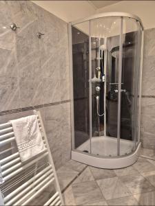 a bathroom with a shower with a mirror and a towel at Appartement d'exception spacieux, 2 chambres, terrasse privée, vue Cathédrale imprenable in Strasbourg +33 photos