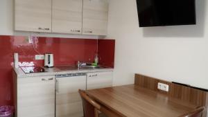 a kitchen with white cabinets and a wooden table at Zum Hopfenbauer in Rudelzhausen