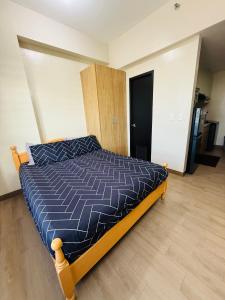 a bedroom with a bed with a blue comforter at Refreshing Condo hotel in General Trias