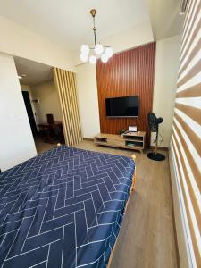 a bedroom with a bed and a flat screen tv at Refreshing Condo hotel in General Trias