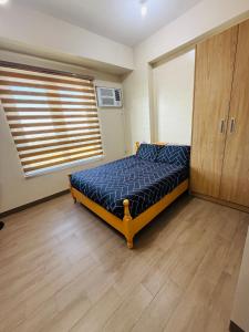 a bedroom with a bed and a wooden floor at Refreshing Condo hotel in General Trias +1 photo