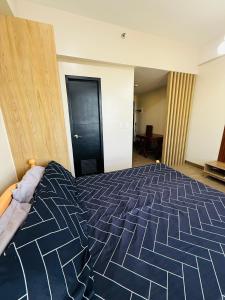 a bedroom with a large bed with a blue and white comforter at Refreshing Condo hotel in General Trias