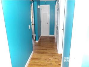 a hallway of a room with blue walls and wooden floors at Summer Sea Vacation Rental in South Yarmouth +3 photos