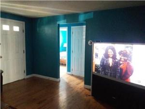 a living room with a flat screen tv and blue walls at Summer Sea Vacation Rental in South Yarmouth