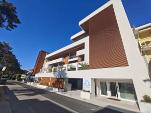 a white building with a brown roof at Libra Aparthotel in Bibione