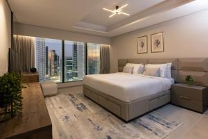 a bedroom with a large bed and large windows at Thirty Five Westbay Luxury Apartments in Doha