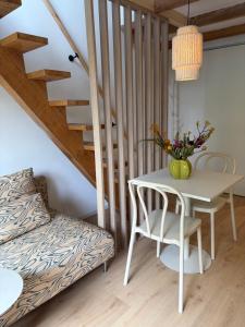 a white table and chair in a room with a staircase at De groene salon in Broek in Waterland