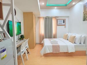 a bedroom with a bed and a desk in a room at Sunvida Tower Across SM Cebu CITY VIEW in Cebu City