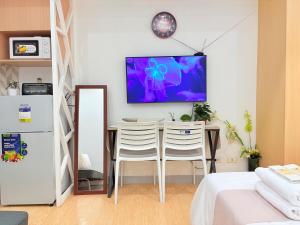 a room with a table and two chairs and a tv on the wall at Sunvida Tower Across SM Cebu CITY VIEW in Cebu City