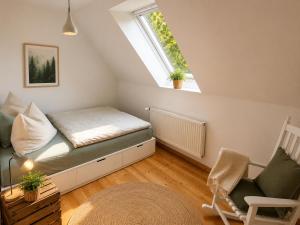 a small attic room with a bed and a window at Amrum Family Hideaway-Grosse Wohnung in Norddorf für bis zu 6 Personen in Norddorf