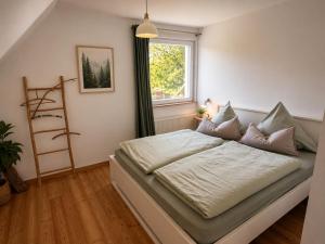 a bed in a room with a window at Amrum Family Hideaway-Grosse Wohnung in Norddorf für bis zu 6 Personen in Norddorf