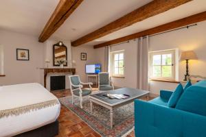 a bedroom with a bed and a living room at Hôtel - Restaurant & Spa La Magdeleine - Mathias Dandine in Gémenos