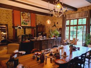 a dining room with a large wooden table with chairs at Ferme de Tayac - Charme avec Pool in Les Eyzies-de-Tayac