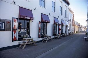 a group of benches sitting outside of a building at Stadshotel Jacob Cats in Brouwershaven
