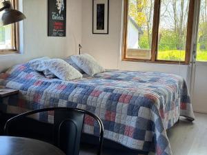 a bedroom with a bed with a quilt on it at Gästhus i lummig trädgård - i idylliska Örum in Löderup