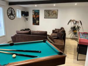 a living room with a pool table and a couch at Le CappyToiT - Gîte climatisé in Cappy