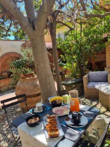 a table with breakfast food on it under a tree at B&B Firenze 400 in Florence