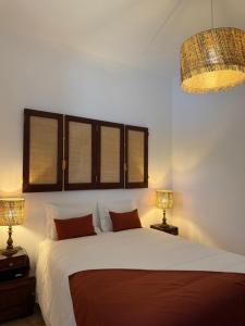 a bedroom with a large white bed with two lamps at Quinta do Passal in Coimbra +4 photos