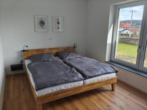 a bed in a room with a large window at Alpenblick Living in Stetten