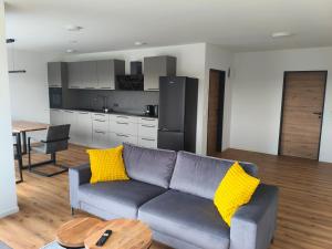 a living room with a couch and a table and a kitchen at Alpenblick Living in Stetten