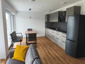 a living room with a couch and a kitchen at Alpenblick Living in Stetten