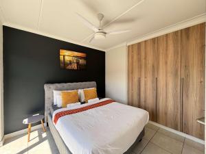 a bedroom with a bed and a ceiling fan at Onyx Oasis in Ballito